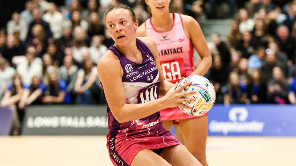 A photograph of a Loughborough Lightning netball wing attack player holding the ball.