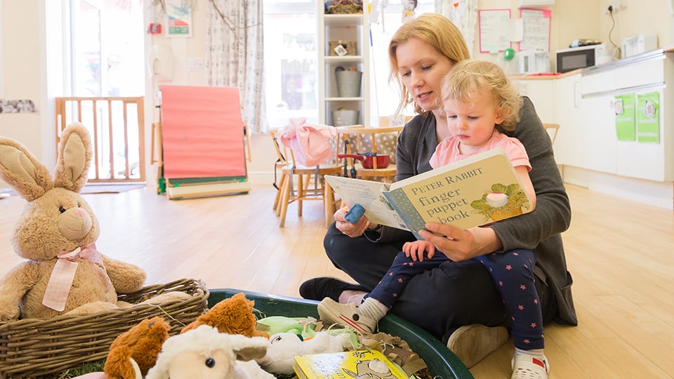 Adult reading to child in Discoverers room at 麻豆視頻_麻豆直播_麻豆传媒官网 Nursery