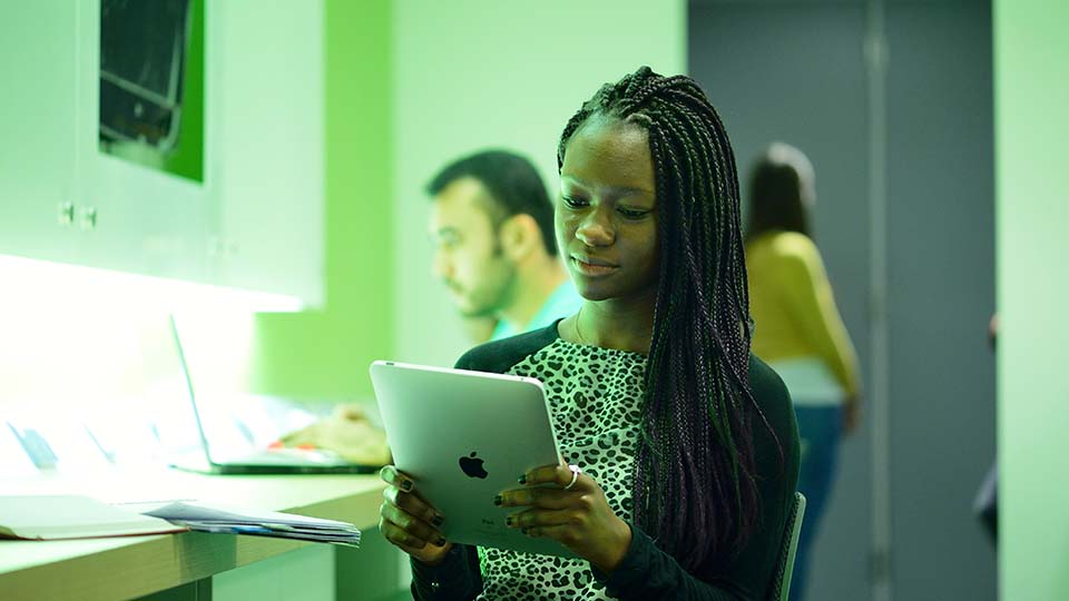 A student reading on an ipads.