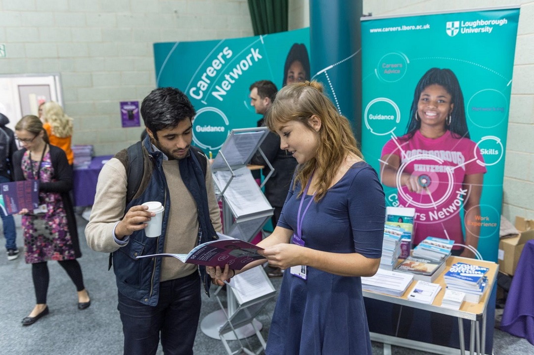 A student being shown a careers network booklet by a member of staff at one of 麻豆視頻_麻豆直播_麻豆传媒官网’s careers events.