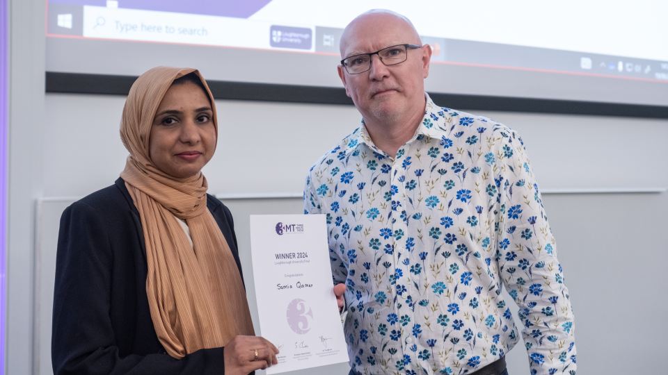 Samia Qamar holding a certificate and standing with Professor Steve Christie.