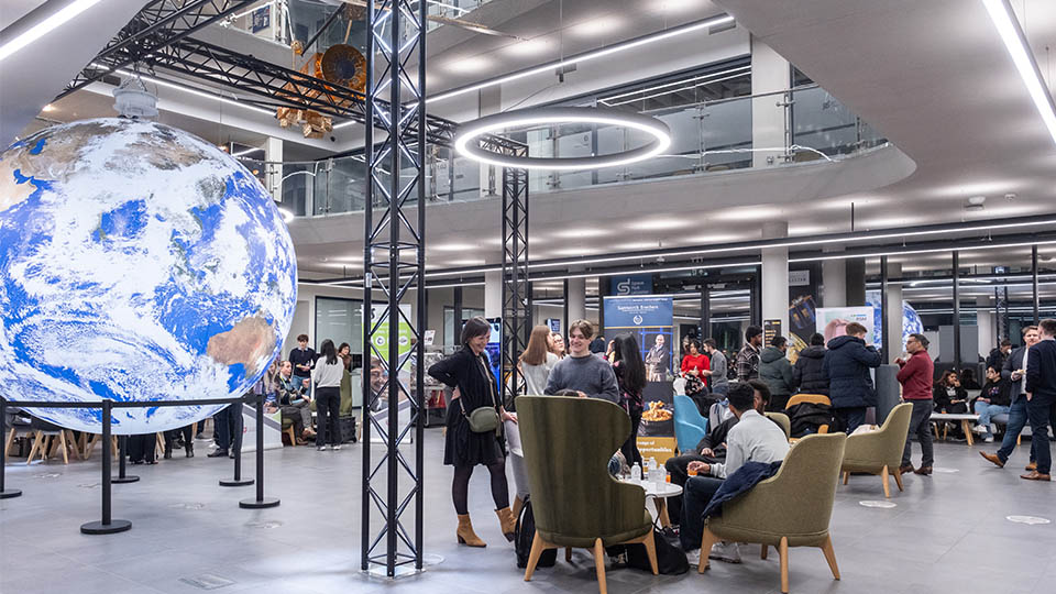 Photo of inside the Space Park with people standing in groups and talking to each other