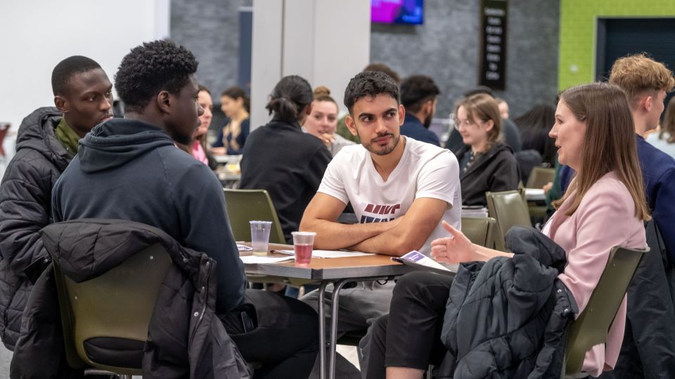 Students sat at tables talking at a 2023 Mock Assessment Centre.