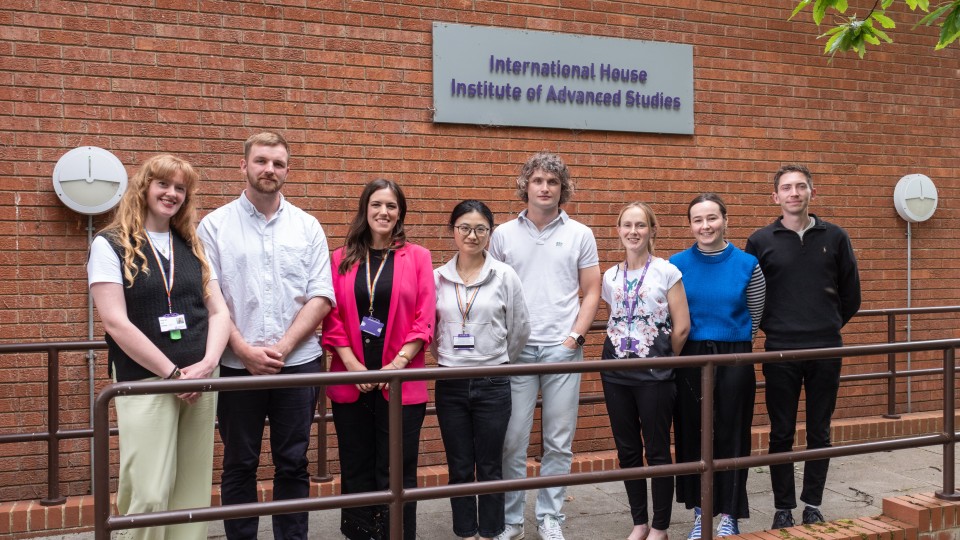 A group of people posing in front of the International House