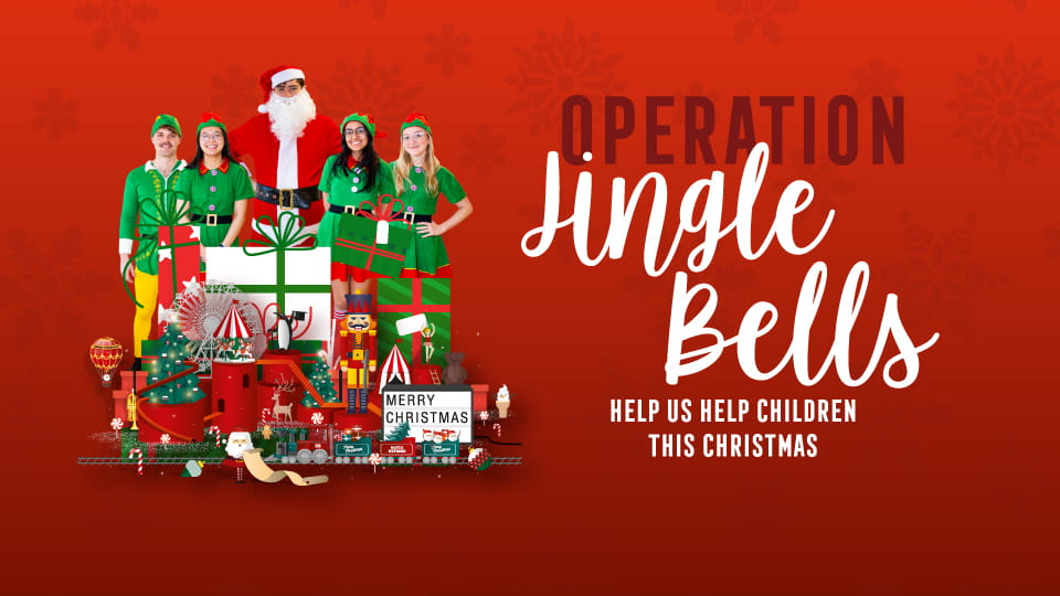 Four people dressed as elves and one dressed as Santa Claus standing behind a pile of toys and the title 'Operation Jingle Bells, help us help children this Christmas'.