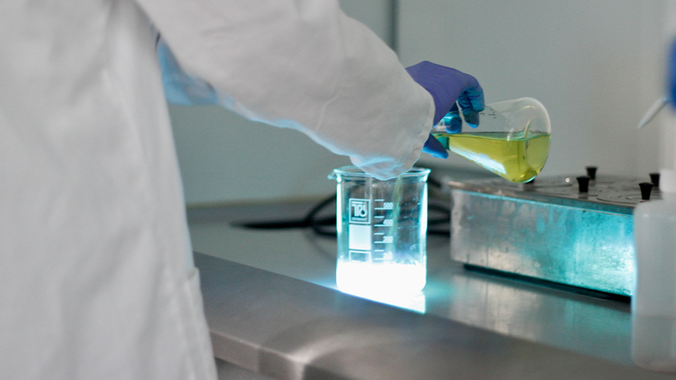 Student creating a glowing solution in a lab