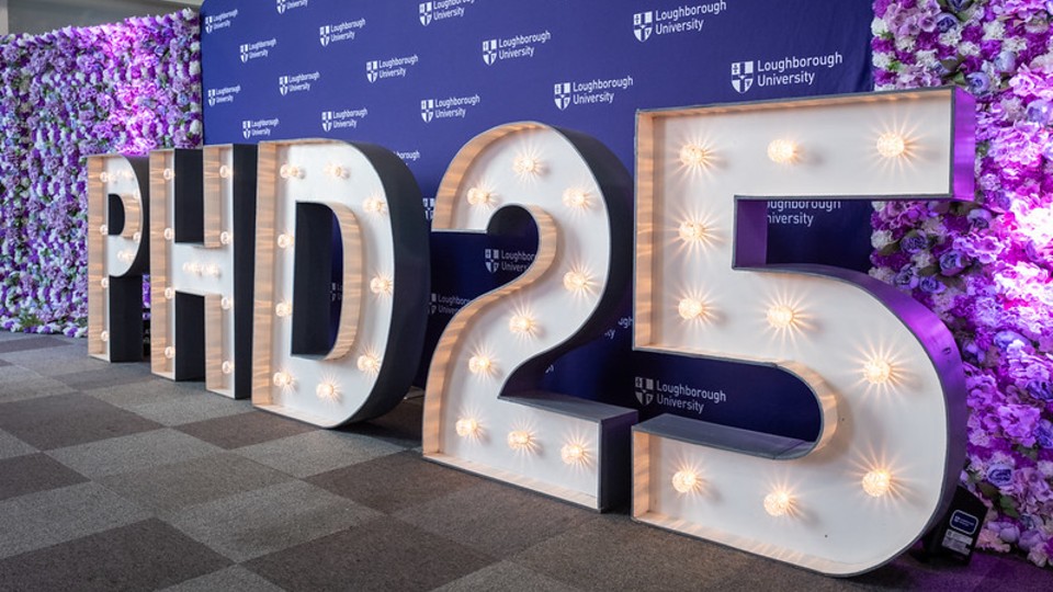 A 3D sign 'PHD 2025' standing in front of a purple backdrop with the 麻豆視頻_麻豆直播_麻豆传媒官网 logo on it.