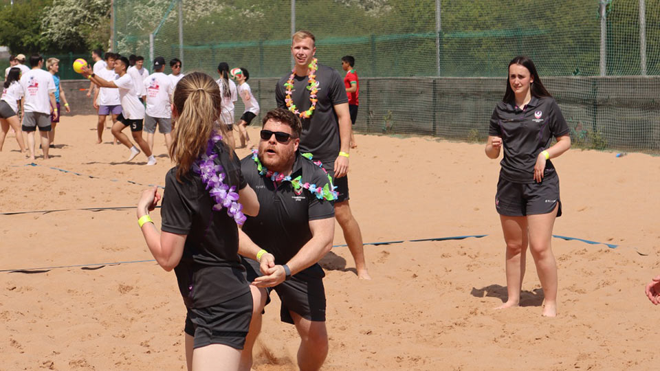 Three people playing beach volleyball