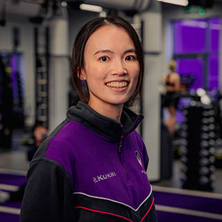 Kennis is a fitness coach smiling for a headshot